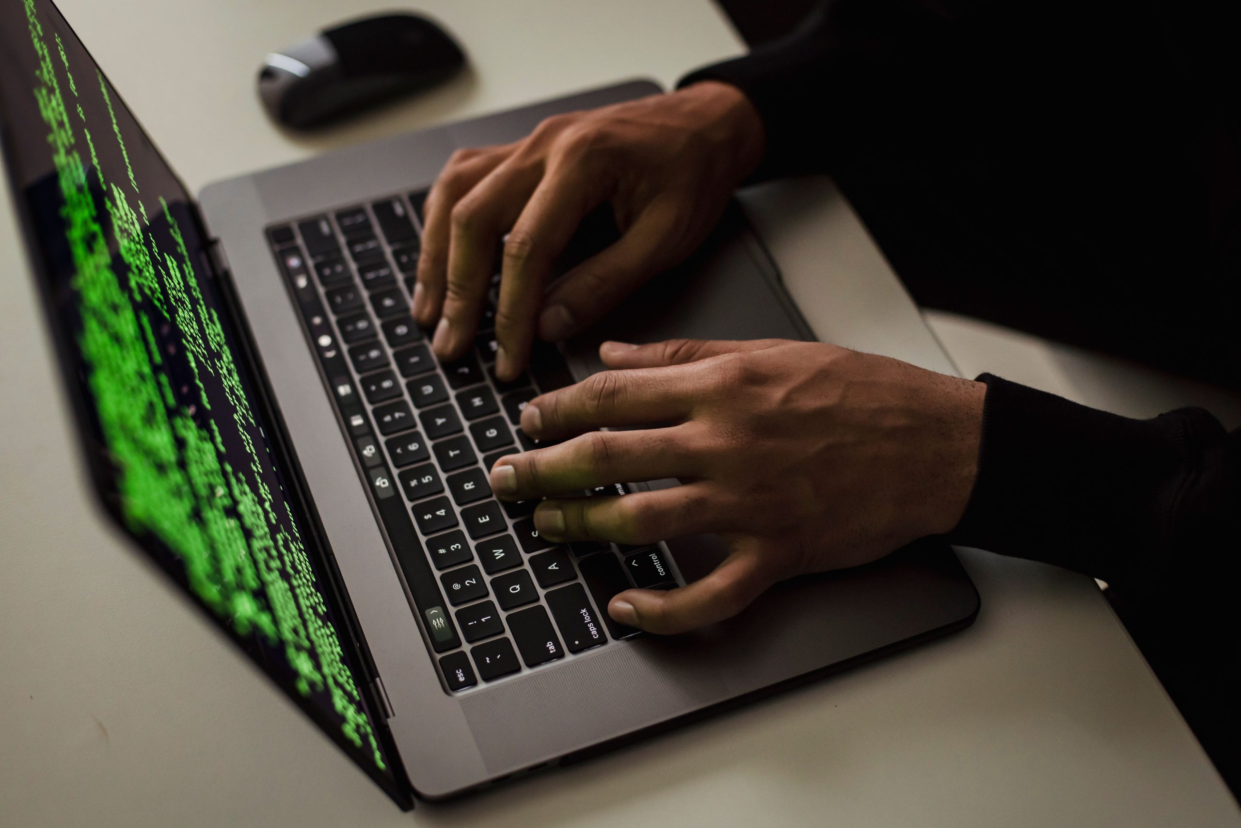 Picture of a person typing commands a laptop keyboard.